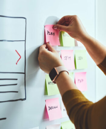 Female web designer planning website ux app development on whiteboard